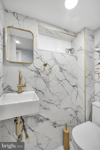 a bathroom with a sink toilet and mirror