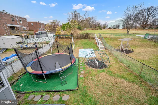 a view of a swimming pool with a patio and a yard