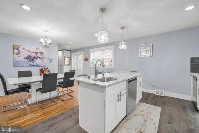 a open kitchen with stainless steel appliances granite countertop a stove and a view of living room