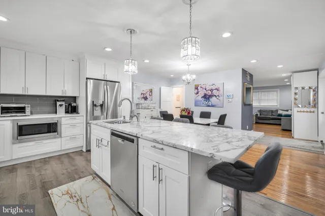 a kitchen with kitchen island a counter space a sink appliances and cabinets