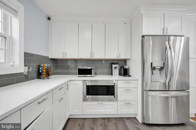 a kitchen with white cabinets and white stainless steel appliances and refrigerator