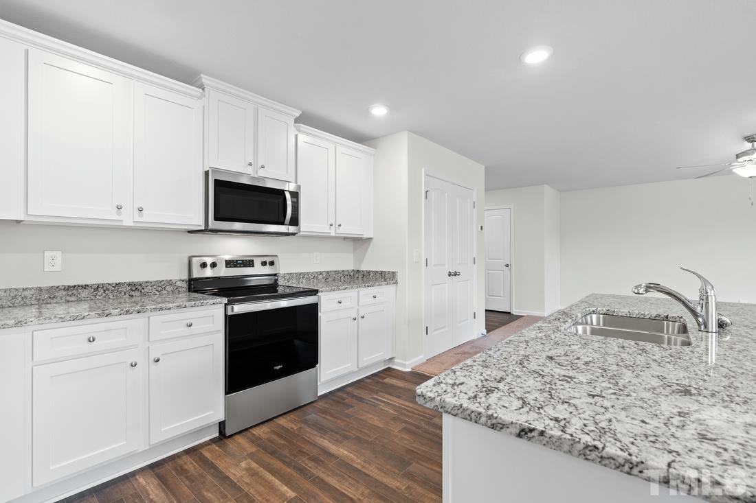 533 Crackling Court Zebulon, NC 27597 - Photo 3 of 14 a kitchen with granite countertop a sink and white cabinets
