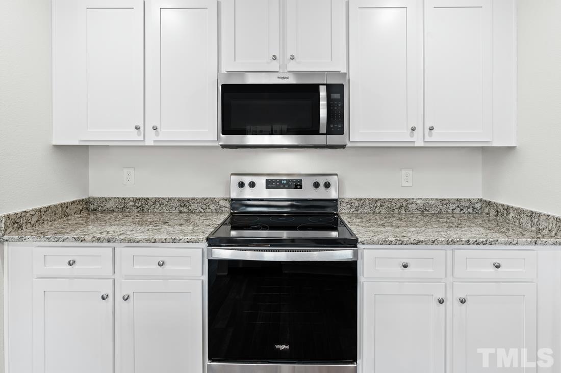 533 Crackling Court Zebulon, NC 27597 - Photo 5 of 14 a kitchen with stainless steel appliances granite countertop white cabinets and a stove a oven with granite countertops