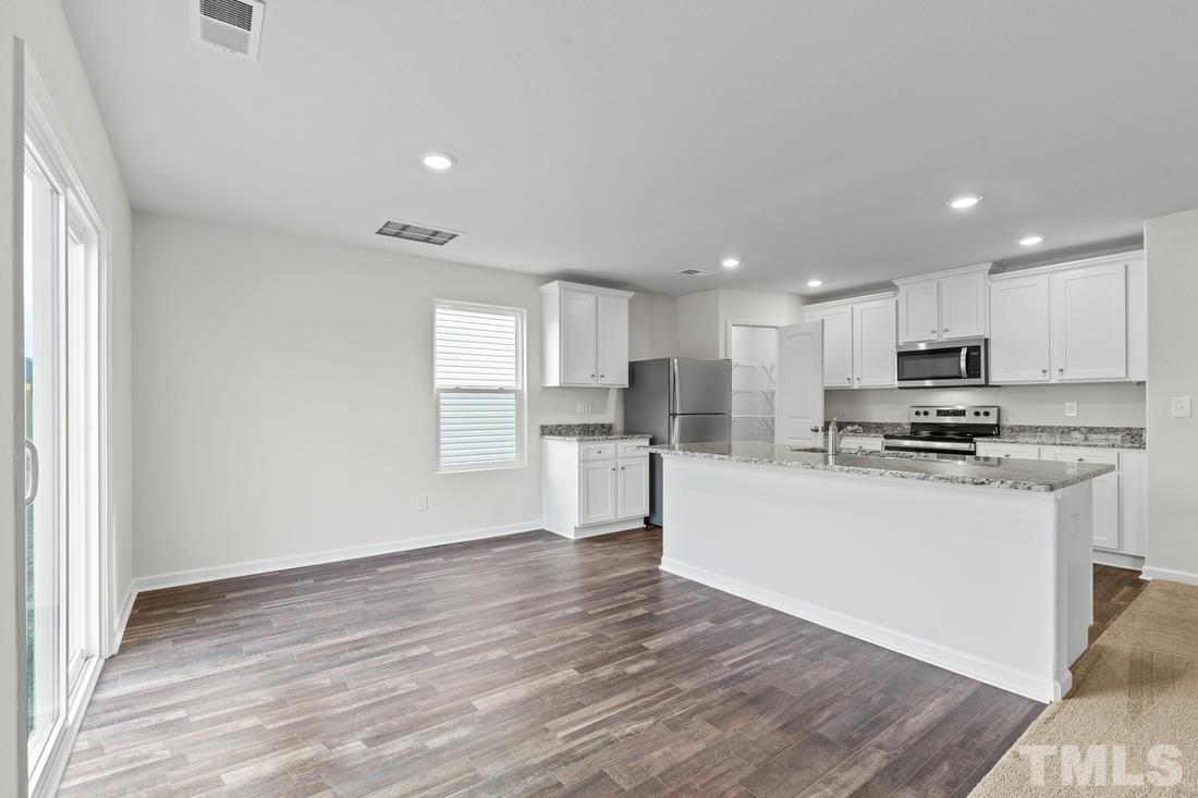 533 Crackling Court Zebulon, NC 27597 - Photo 6 of 14 a kitchen with stainless steel appliances granite countertop a refrigerator sink and white cabinets