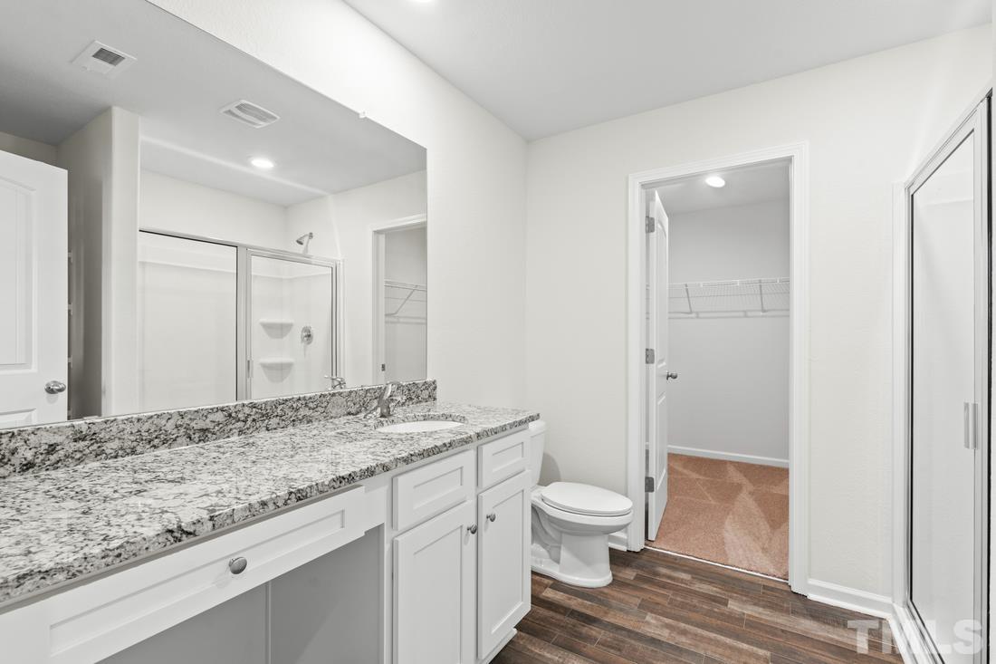 533 Crackling Court Zebulon, NC 27597 - Photo 10 of 14 a bathroom with a granite countertop sink a toilet and shower
