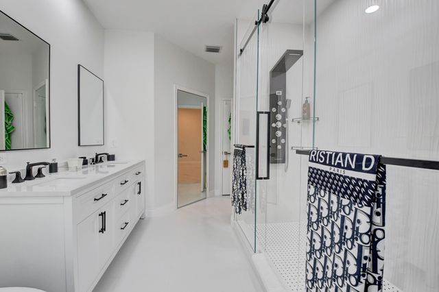 a bathroom with a double vanity sink mirror and shower