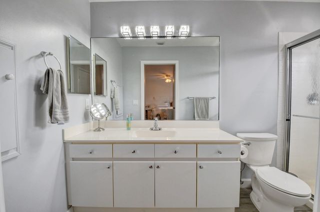 a bathroom with a sink a toilet a mirror and shower