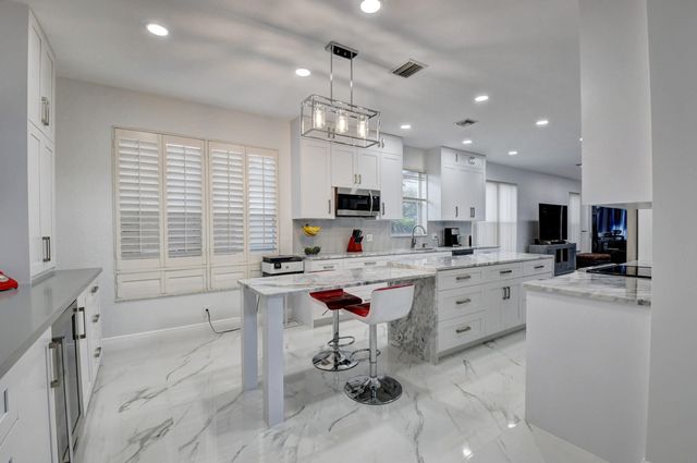 a kitchen that has a lot of cabinets in it and appliances
