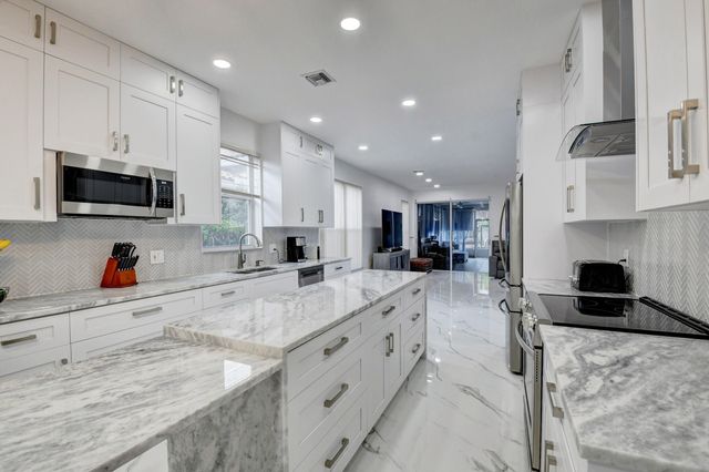 a kitchen with granite countertop a sink and steel appliances
