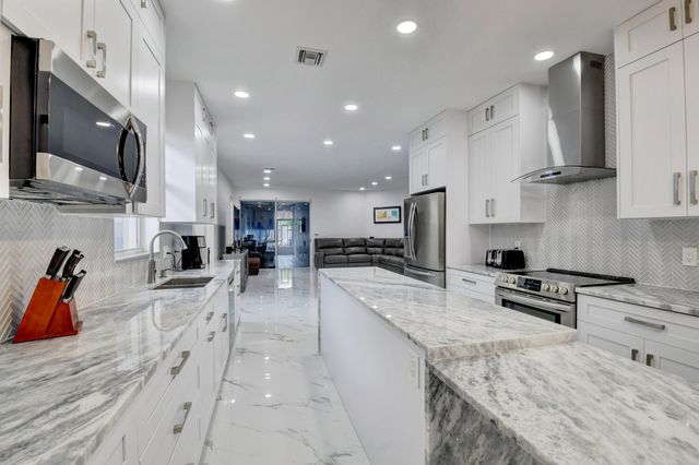 a large kitchen with stainless steel appliances kitchen island granite countertop a large counter top stainless steel appliances and cabinets