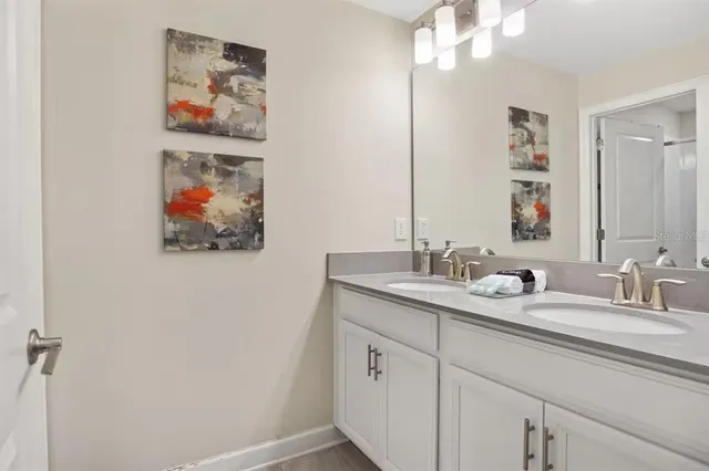 a bathroom with a double vanity sink and a mirror