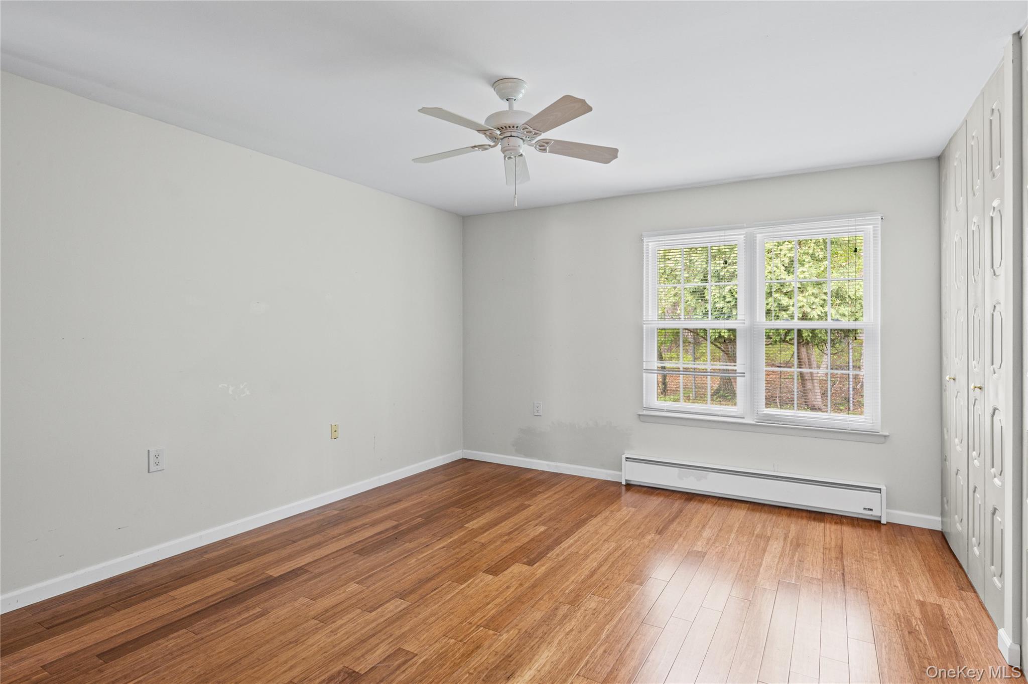 220 Belfast Lane Ridge, NY 11961 - Photo 37 of 44 wooden floor in an empty room with a window