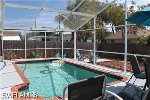 a view of a swimming pool with a patio and a yard