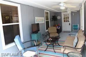 a living room with furniture a flat screen tv and a window