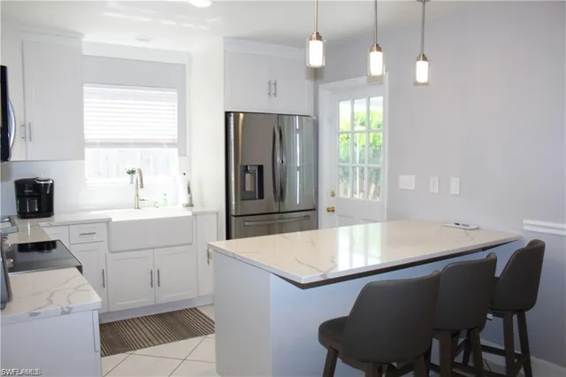 a kitchen with a table chairs sink and refrigerator