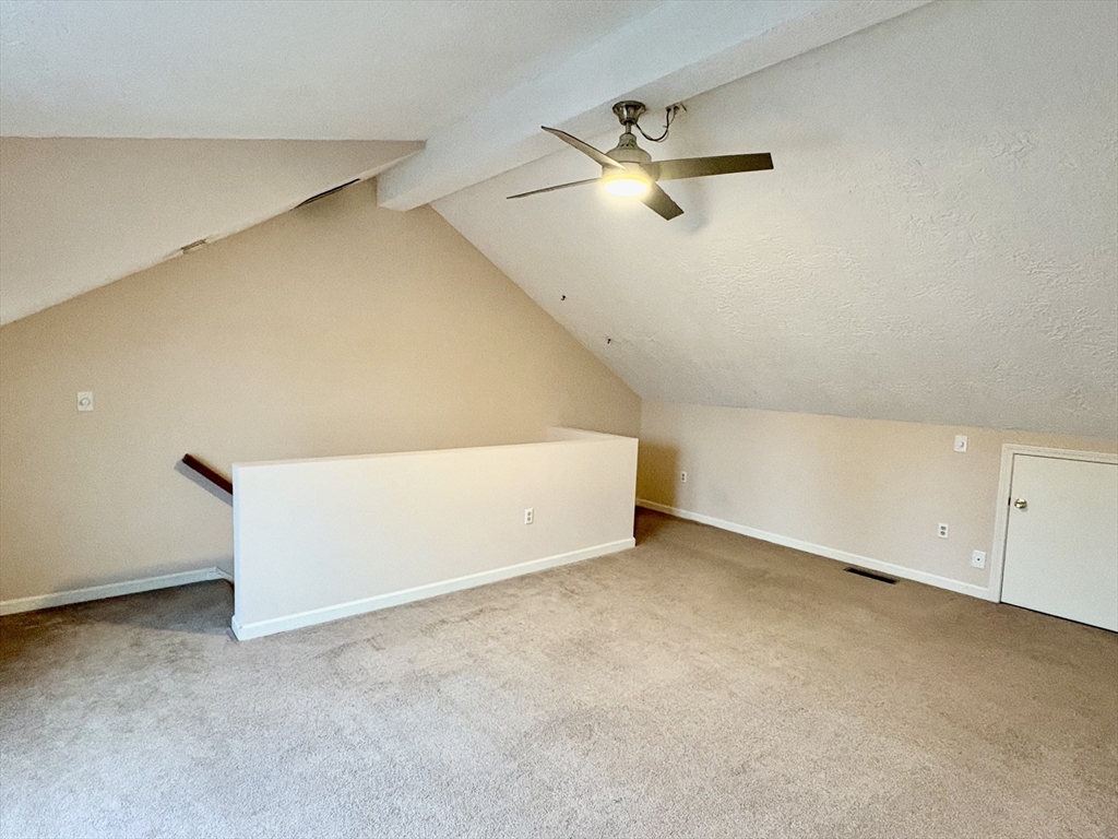 224 Park Street, Unit B2 Stoneham, MA 02180 - Photo 25 of 35 an empty room with a ceiling fan and carpet