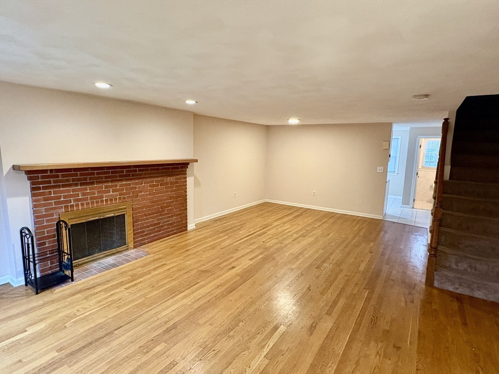 224 Park Street, Unit B2 Stoneham, MA 02180 - Photo 4 of 35 a view of an empty room with wooden floor fireplace and a window