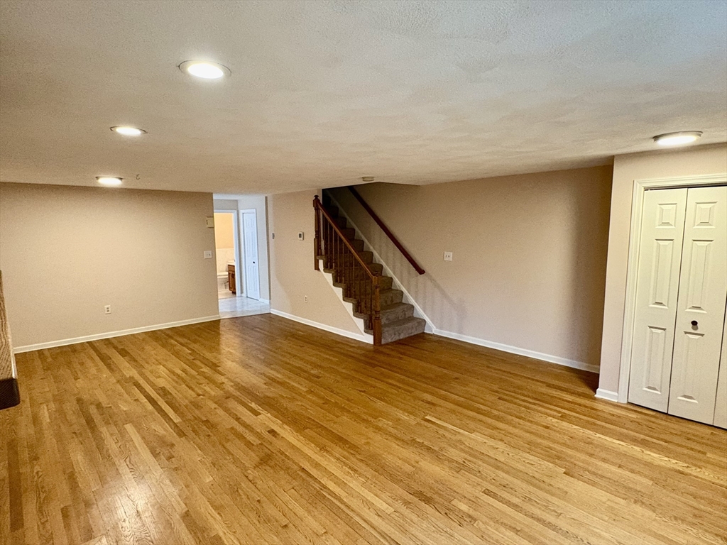 224 Park Street, Unit B2 Stoneham, MA 02180 - Photo 6 of 35 a view of an empty room with wooden floor and stairs