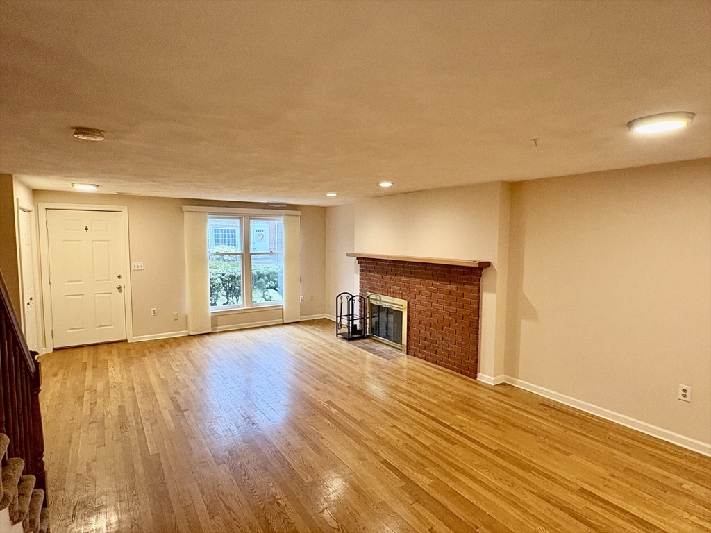 224 Park Street, Unit B2 Stoneham, MA 02180 - Photo 8 of 35 a view of empty room with wooden floor and fireplace