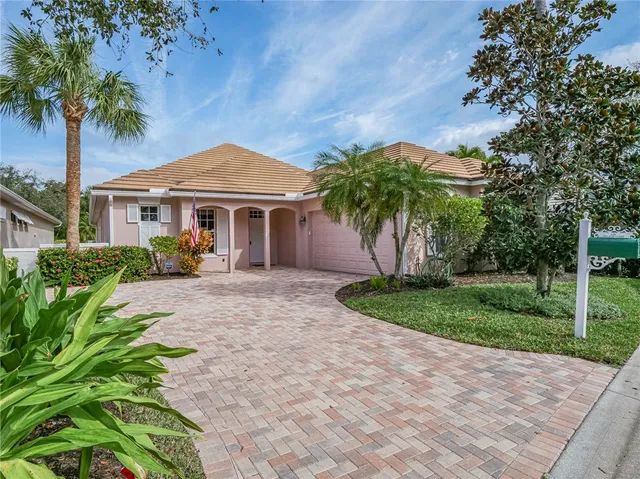 a front view of a house with a garden and trees