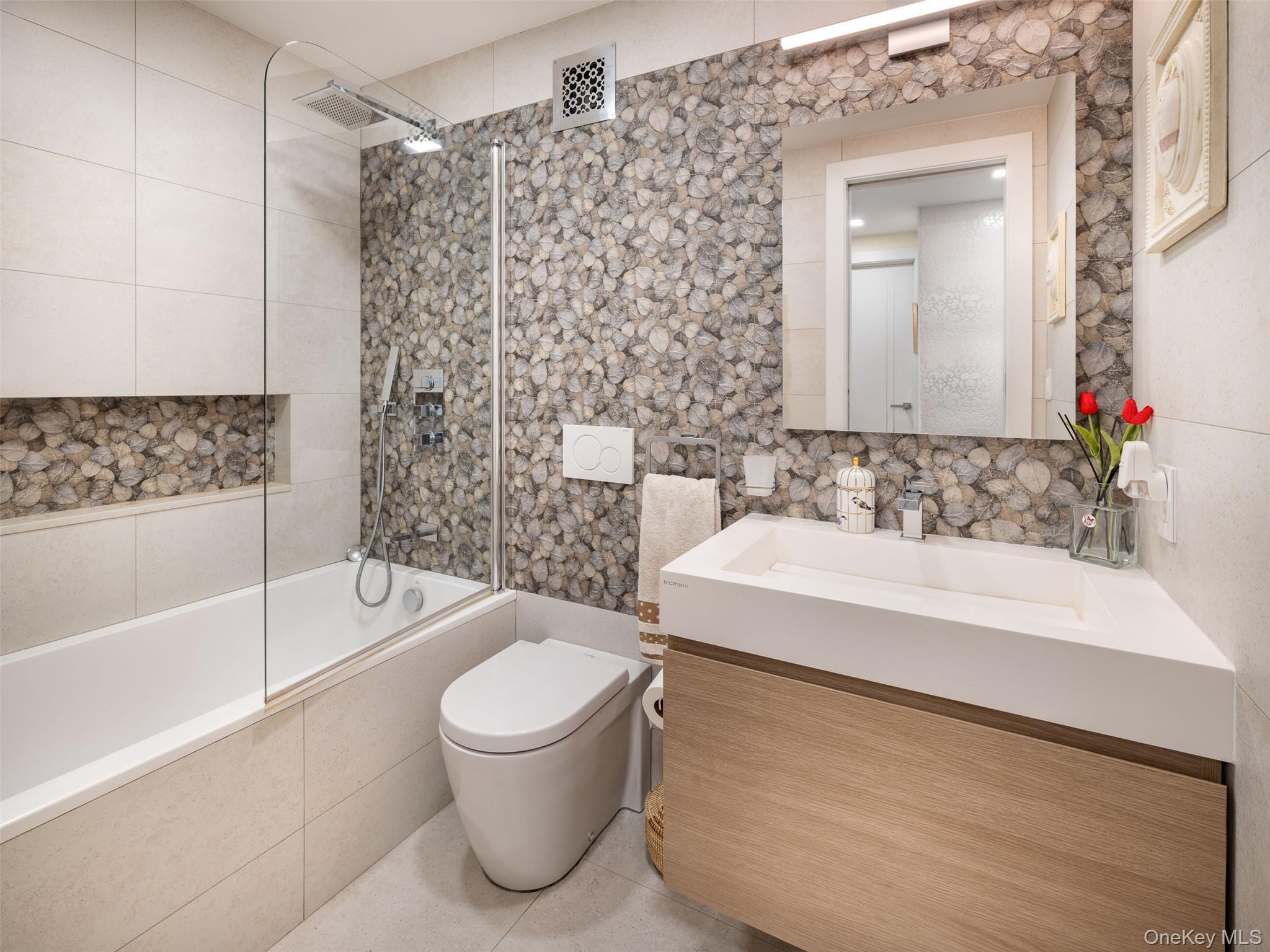 25-40 Shore Boulevard, Unit 17K Queens, NY 11102 - Photo 12 of 19 a bathroom with a sink a toilet and bathtub