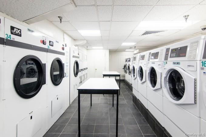 25-40 Shore Boulevard, Unit 17K Queens, NY 11102 - Photo 18 of 19 a utility room with dryer washer and a kitchen view