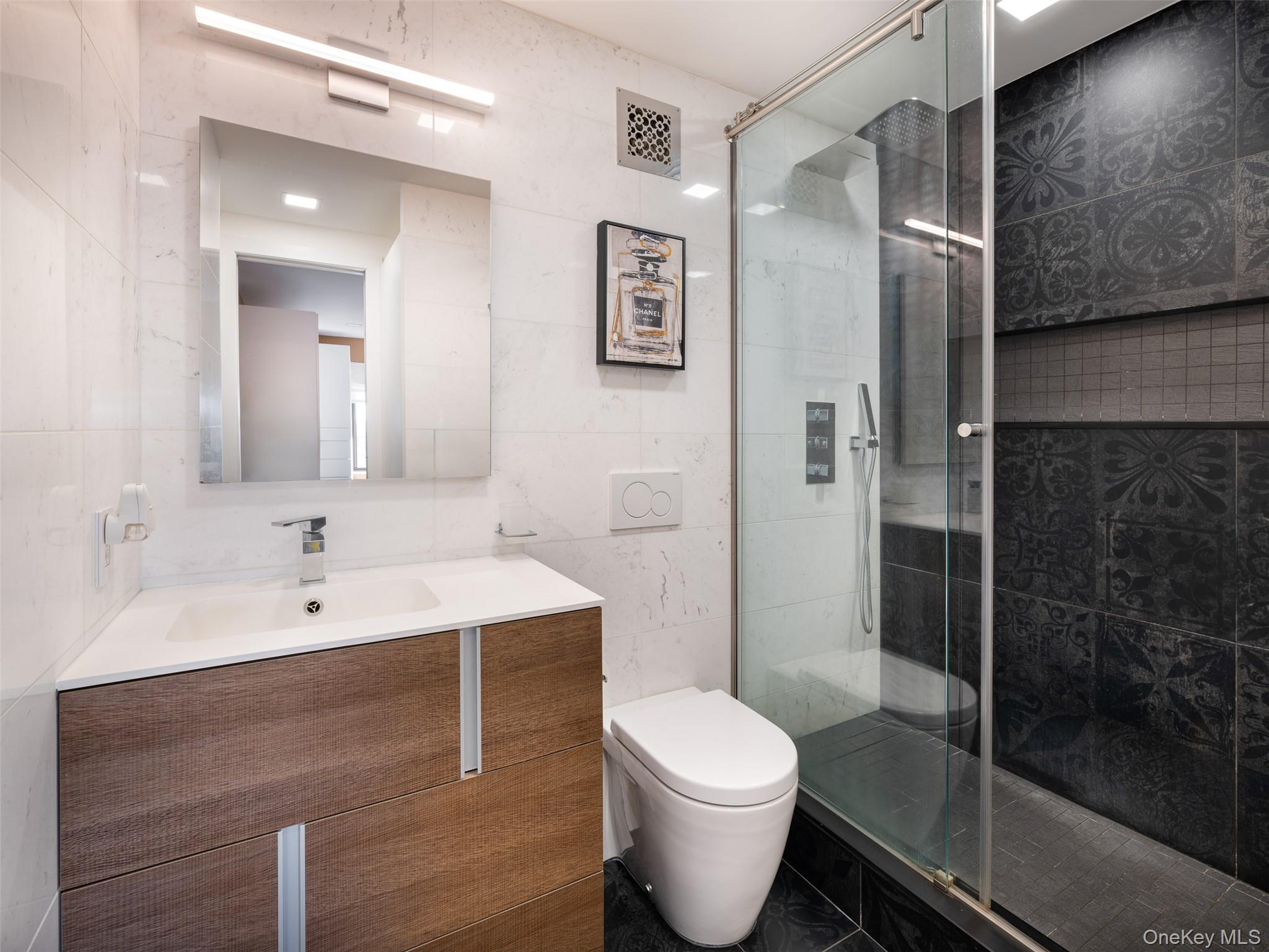 25-40 Shore Boulevard, Unit 17K Queens, NY 11102 - Photo 9 of 19 a bathroom with a toilet sink and shower