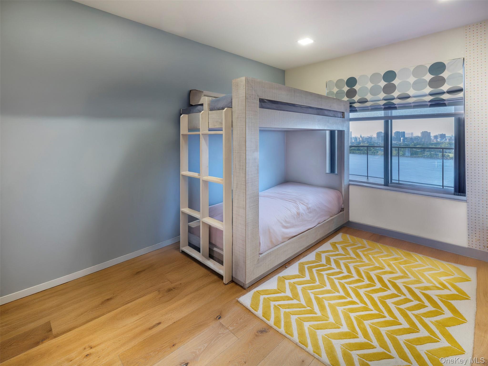 25-40 Shore Boulevard, Unit 17K Queens, NY 11102 - Photo 10 of 19 a bedroom with a bed and wooden floor