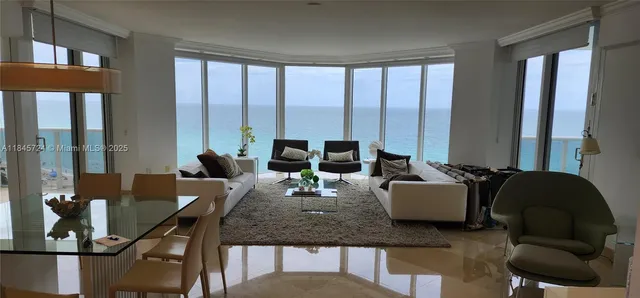 a living room with furniture and floor to ceiling windows
