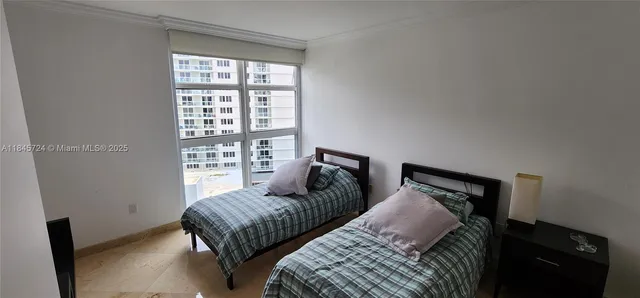 a bedroom with two beds and a window