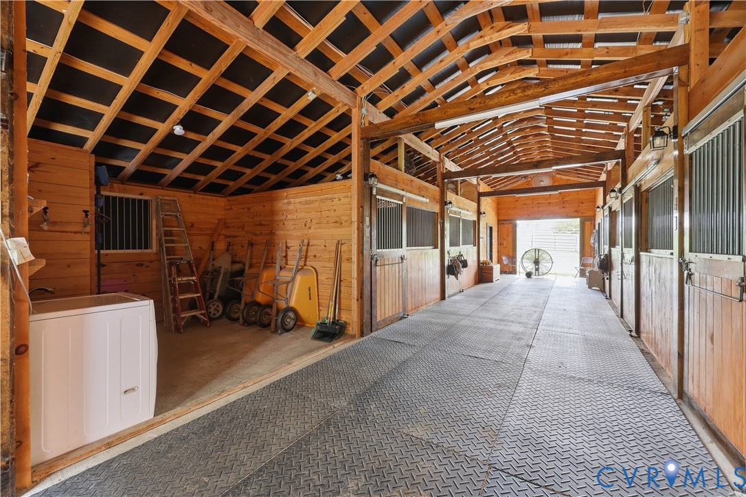 25181 West Soap Stone Road Jetersville, VA 23083 - Photo 41 of 54 Wood-paneled barn interior featuring multiple stal
