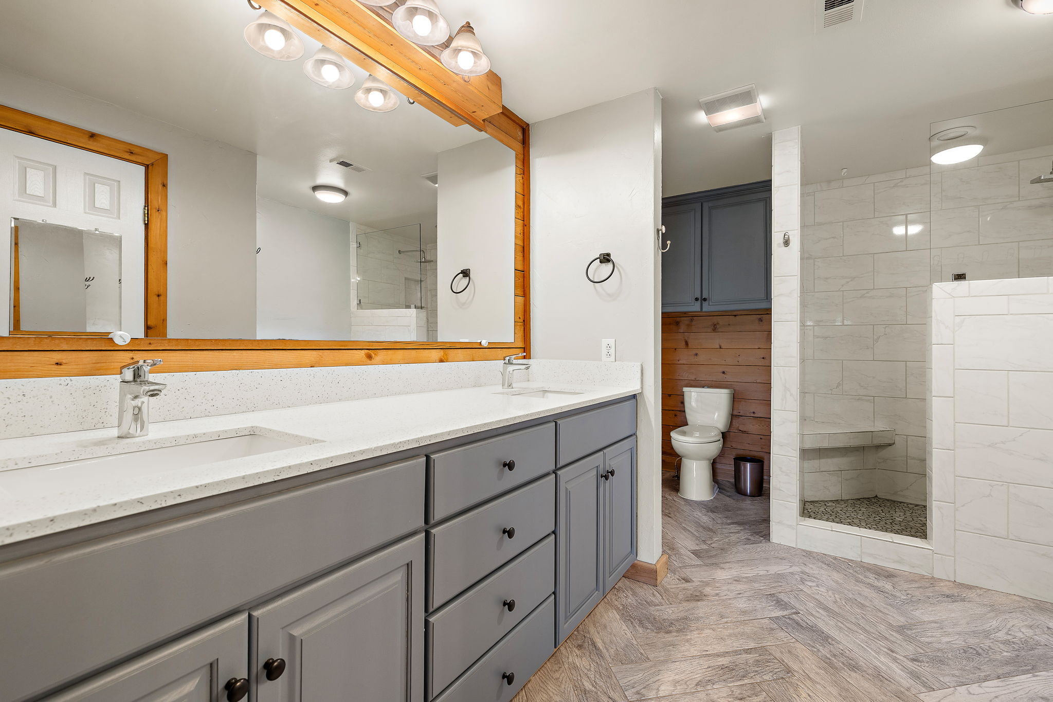 571 Balch Road Elgin, TX 78621 - Photo 16 of 33 Double vanity with a speckled countertop, undermount sinks, and grey cabinetry