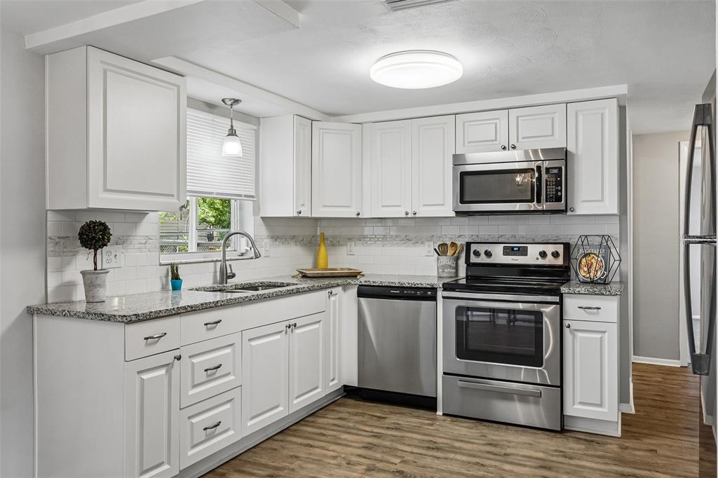 7215 Mayfield Drive Port Richey, FL 34668 - Photo 20 of 52 a kitchen with a sink stove and microwave