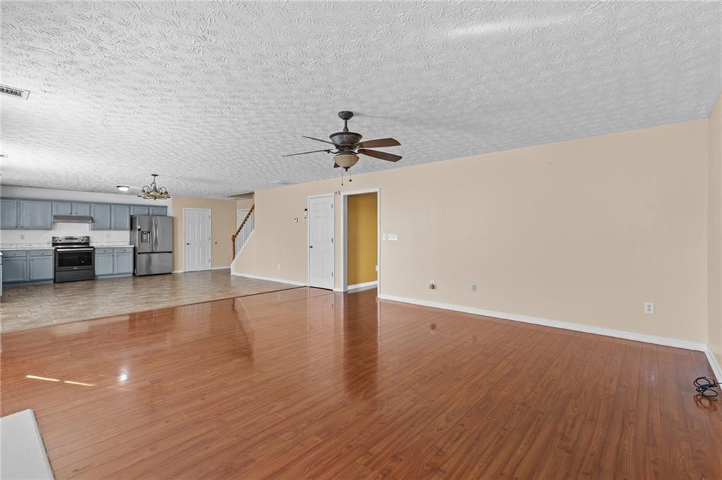 2760 Rusticwood Drive Southwest Snellville, GA 30078 - Photo 14 of 50 an empty room with wooden floor ceiling fan and windows