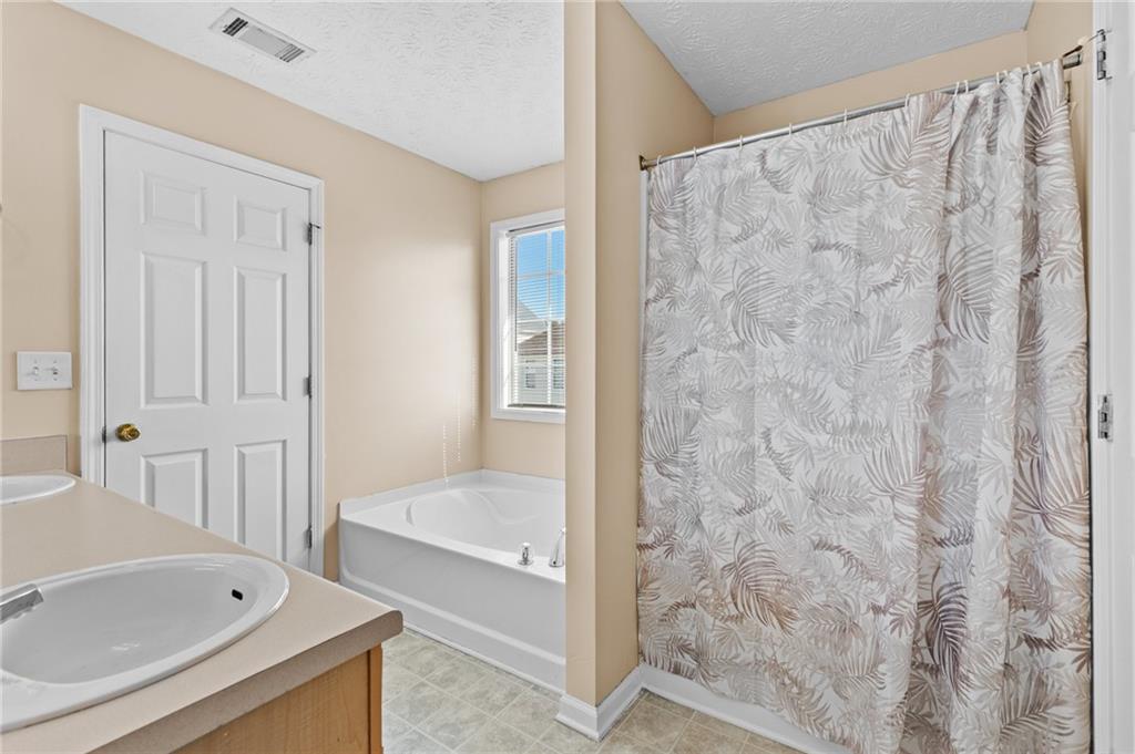 2760 Rusticwood Drive Southwest Snellville, GA 30078 - Photo 28 of 50 a bathroom with a tub and shower