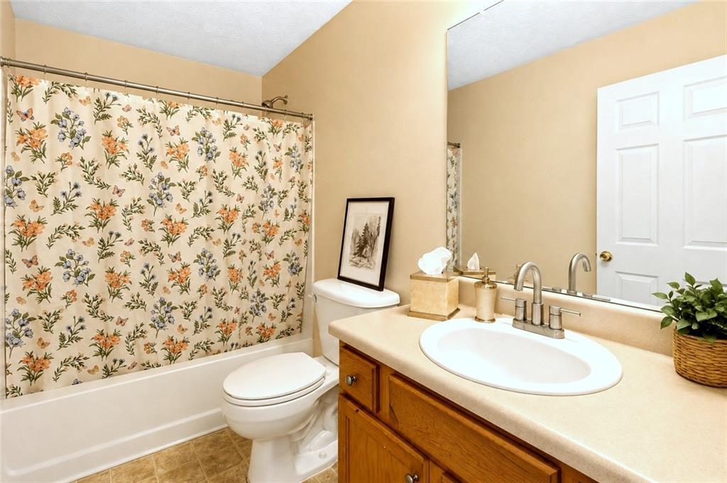 2760 Rusticwood Drive Southwest Snellville, GA 30078 - Photo 33 of 50 a bathroom with a sink a toilet and shower curtain