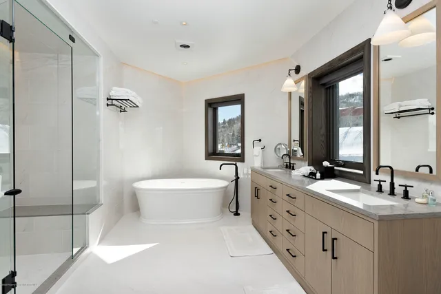a bathroom with a double vanity sink mirror double and bathtub
