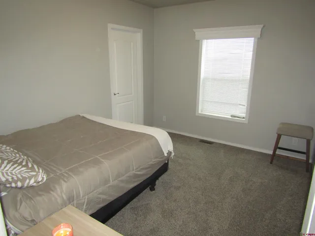 a bed sitting in a bedroom next to a window