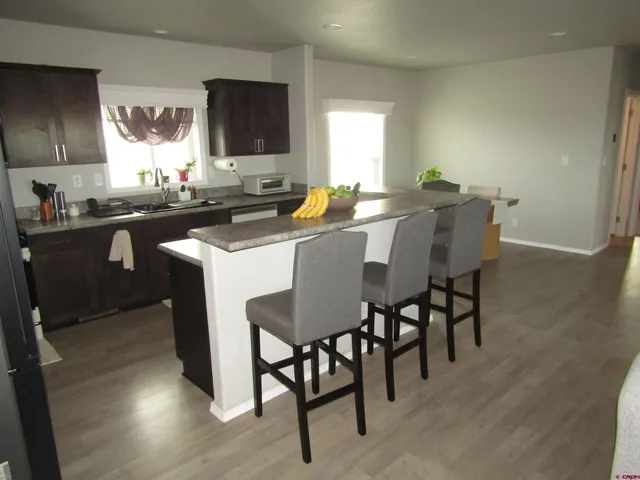 a kitchen with a dining table chairs and sink