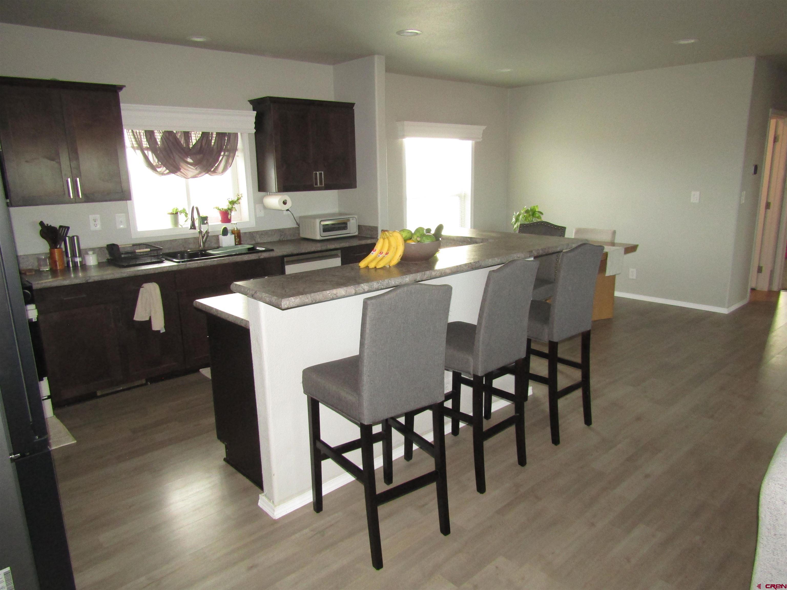 4784 Alpine Ranch Alamosa, CO 81101 - Photo 3 of 15 a kitchen with a dining table chairs and sink