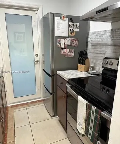 a kitchen with stainless steel appliances granite countertop a refrigerator and a stove