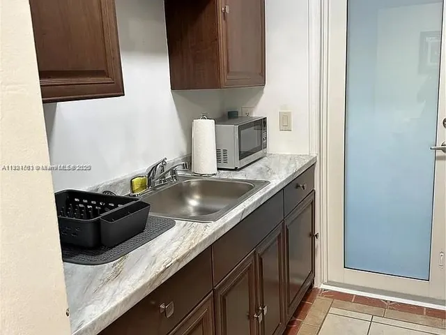 a kitchen with granite countertop cabinets and black appliances