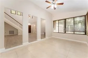 a view of an empty room with a window and a kitchen view