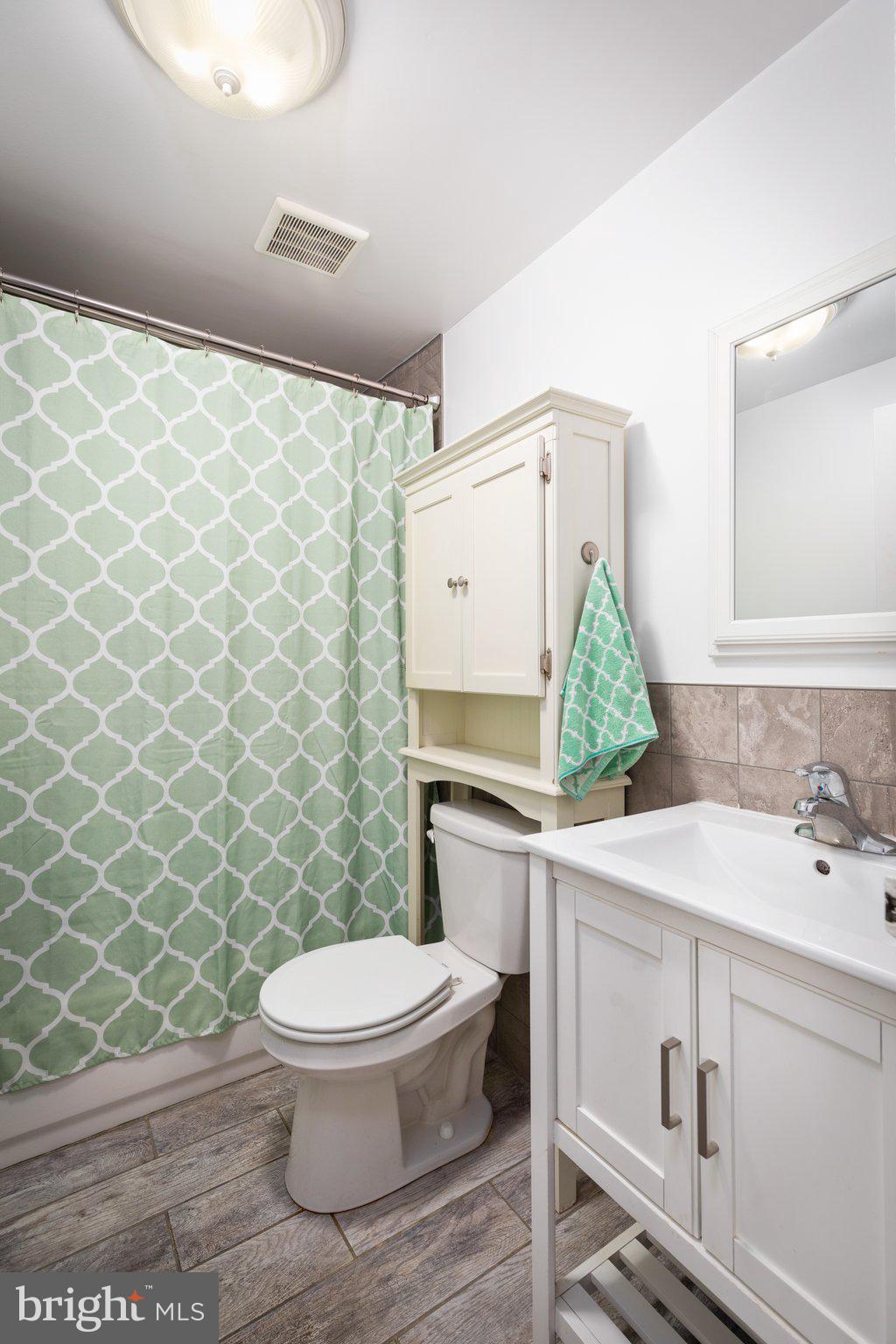 7404 Edsworth Road Dundalk, MD 21222 - Photo 13 of 24 a bathroom with a sink toilet and a mirror