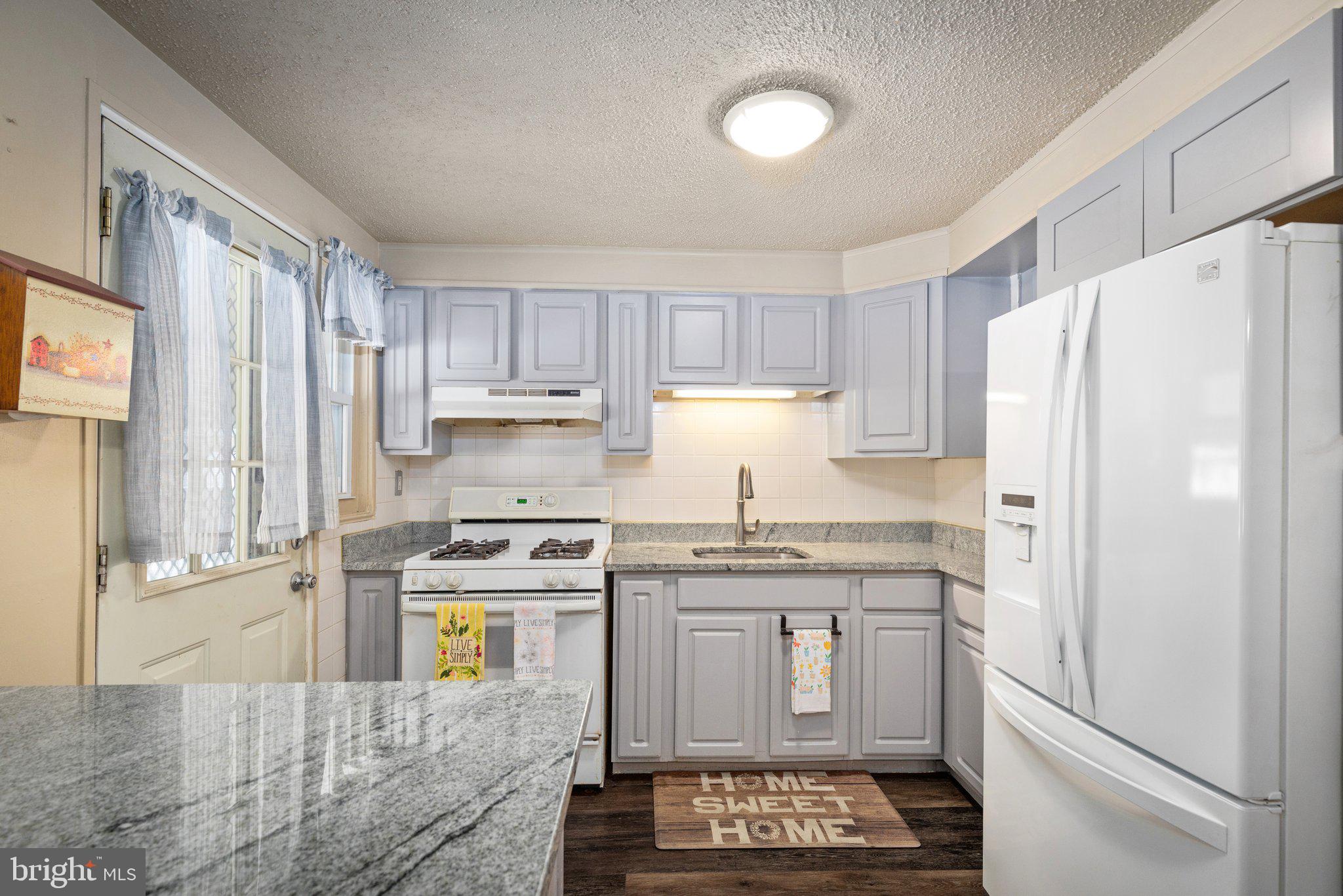 7404 Edsworth Road Dundalk, MD 21222 - Photo 7 of 24 a kitchen with stainless steel appliances a refrigerator stove and sink