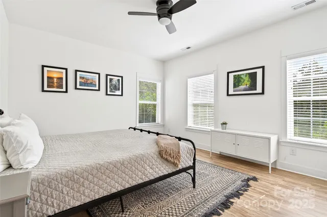 a spacious bedroom with a bed and wooden floor