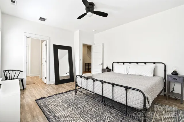 a bedroom with a large bed and a chandelier