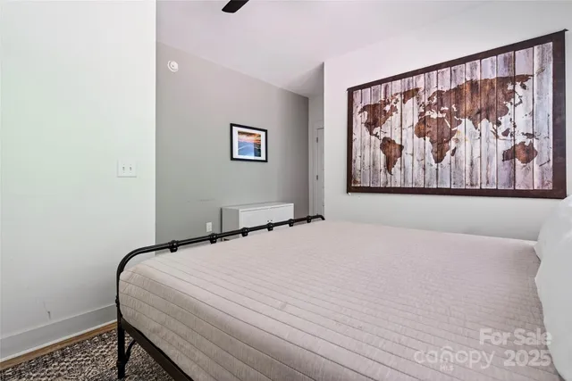 a bedroom with a large bed and a wall painting