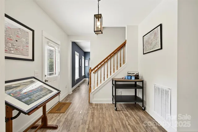 a view of a hallway with wooden floor and stairs