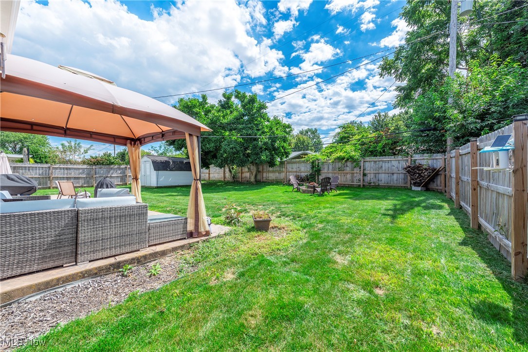 13765 Newton Road Cleveland, OH 44130 - Photo 38 of 42 Fenced backyard featuring a gazebo, a storage unit, a patio area, and an outdoor hangout area